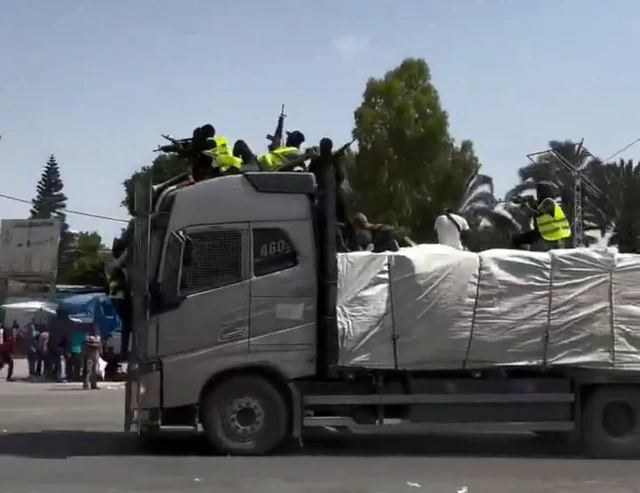 A truck with armed men onboard speeds through the streets of Gaza.