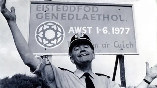 Plismon o flaen arwydd Eisteddfod 1977