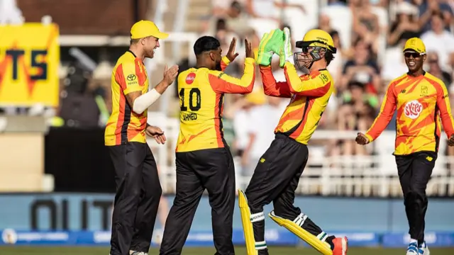 Rehan Ahmed of Trent Rockets celebrates with team mates Sam Cook and Akeal Hosein after taking the wicket of Dan Lawrence