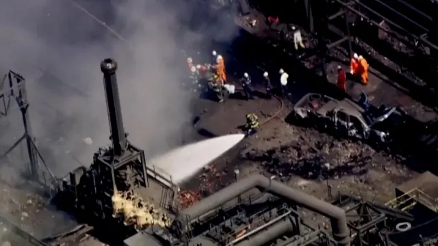 Firefighters spray water on the site of an explosion at US Steel's Clairton Coke Works plant