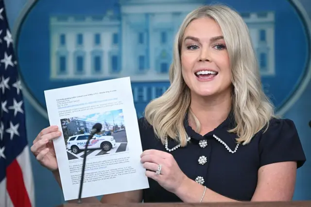 Karoline Leavitt holds up a paper discussing crime in Washington DC