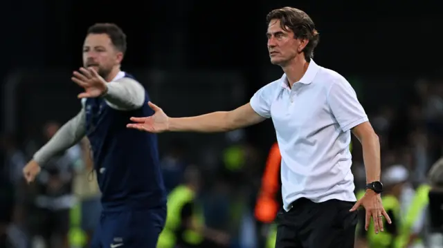 Frank waves instructions from the sideline