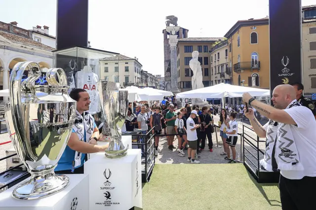 Spurs fans pose with the Super Cup, Europa League and Champions League trophies