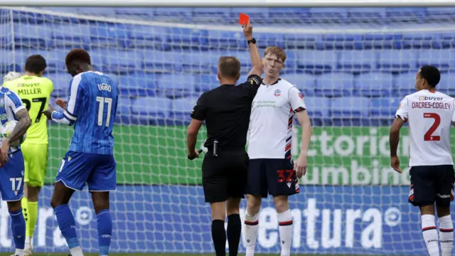 Sam Inwood of Bolton Wanderers is shown a red card by referee Oliver Langford