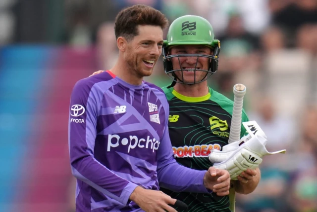 Northern Superchargers' Mitch Santner (left) shares a joke with Southern Brave's Laurie Evans after dismissing him for 53