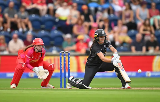 Amelia Kerr of Manchester Originals plays a scoop shot as wicket keeper Sarah Bryce of Welsh Fire looks on