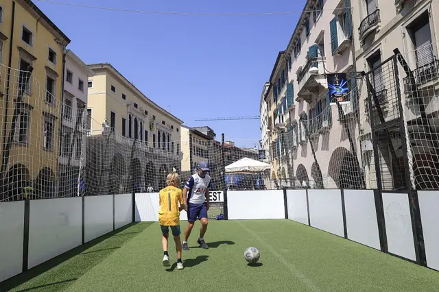 Spurs fans play in a football cage in Udine