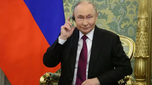 Vladimir Putin sits in a chair