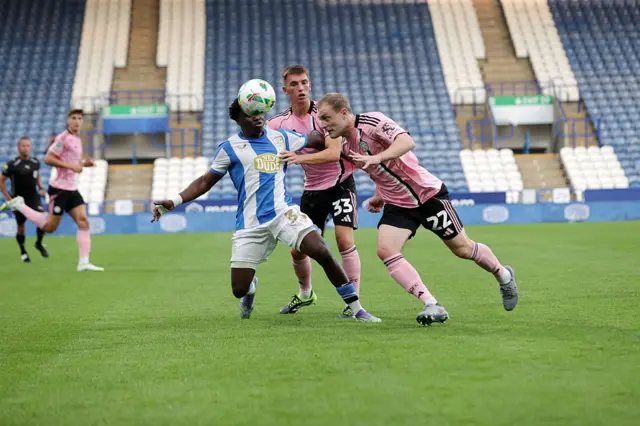 Oliver Skipp of Leicester City and Luke Thomas of Leicester City in action with Cameron Ashia of Huddersfield Town during the Carabao Cup first round match between Huddersfield Town and Leicester City at John Smith's Stadium on August 13, 2025 in Huddersfield, England.