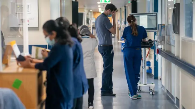 A busy ward featuring doctors and nurses at an NHS hospital