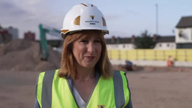 Reeves in a hard hat and high vis at a construction site