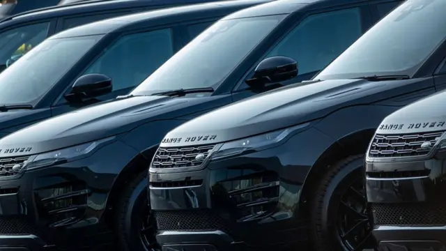 A row of brand new, black Range Rovers