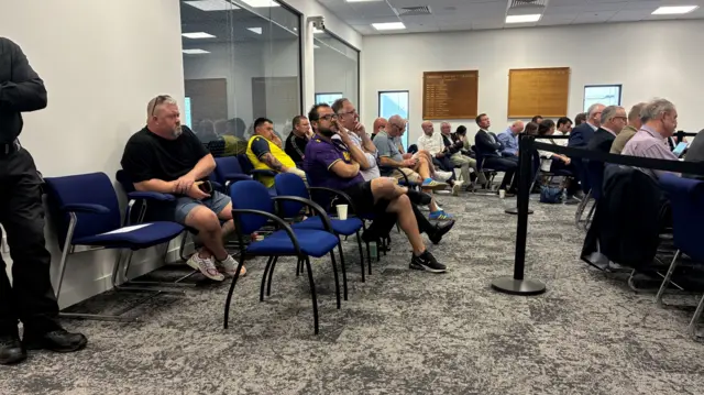 Fans sat in their football shirts in the meeting room