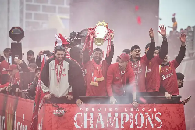 Mohamed Salah celebrates with the Premier League trophy during an open-top bus victory parade