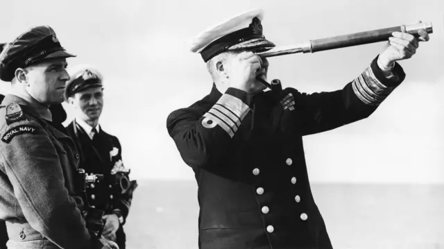 Carl Carlyon looks on in a Royal Navy uniform as  Admiral Sir Bruce Fraser looks through a telescope