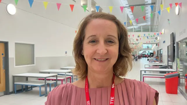 Zoe Lewis, principal of Middlesborough College. She has blonde hair and is wearing a pink top and smiling at the camera