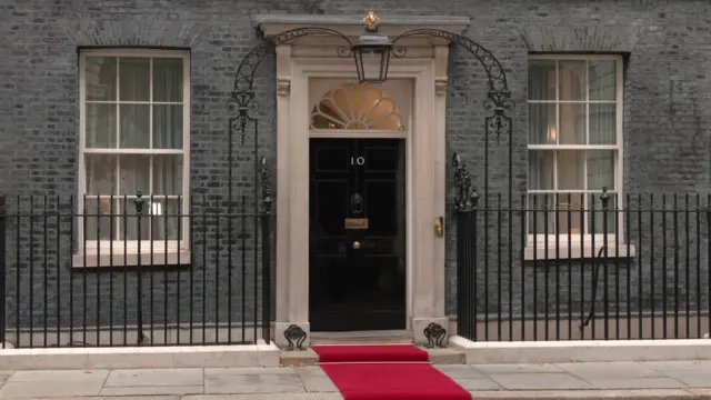 Number 10 Downing Street front door with red carpet rolled out