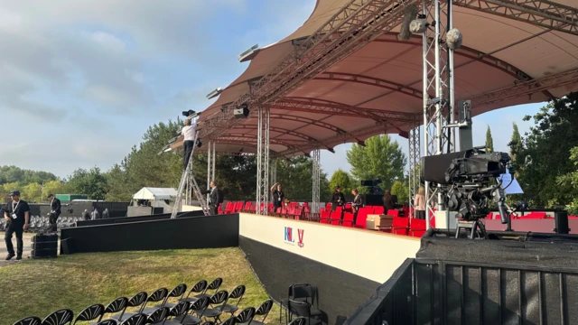 VJ day stage being set up, there is a canopy, chairs and TV cameras visible, as staff work on the stage