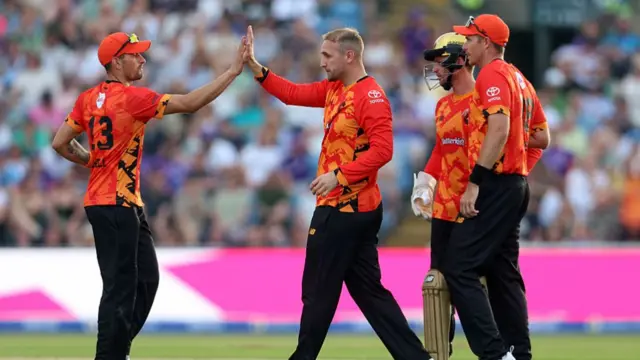 Liam Livingstone high fives and celebrates with teammates after taking the wicket of Zak Crawley.