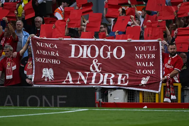 Fans hold up a 'You'll never walk alone' banner with Diogo Jota and Andre Silva's names on