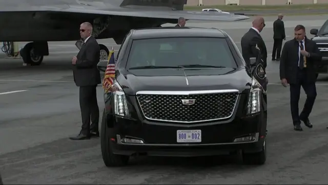 The US presidential limousine, the Beast, parked on the tarmac of Elmendorf-Richardson base surrounded by US security service agents