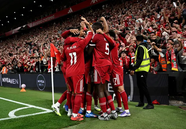 Liverpool players celebrate by the corner flag