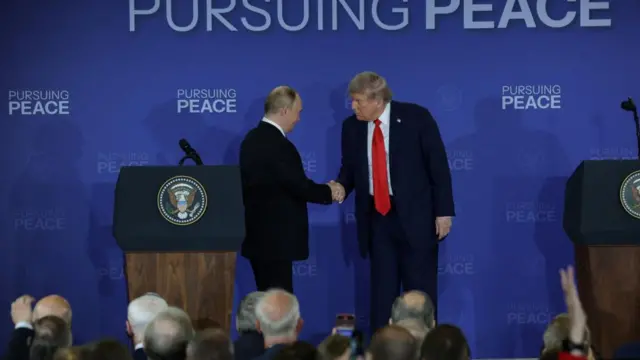 Vladimir Putin and Donald Trump shake hands