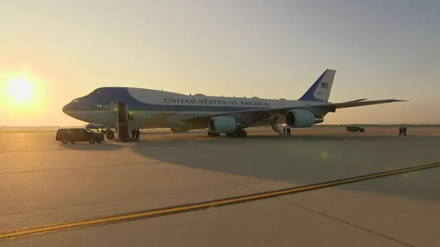 Air Force One sitting on tarmac with sunset in the background