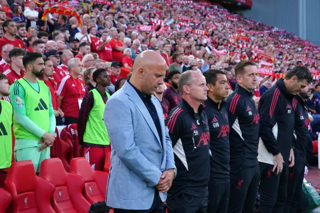 Arne Slot bows his head as he stands for the minute's silence