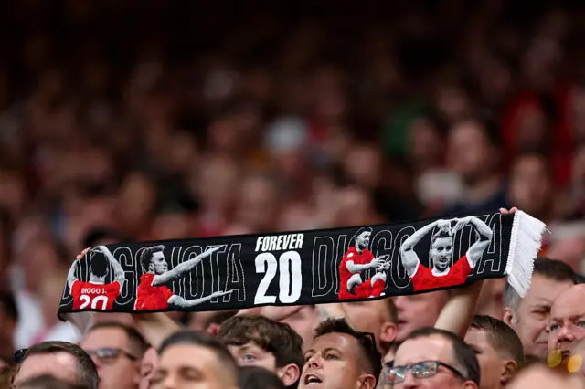 Liverpool fan holds up a Diogo Jota 20 scarf