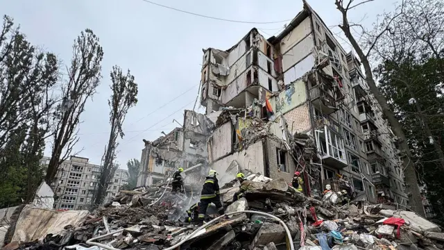 Ukrainian emergency work amid the rubble of a residential building after an air attack in Kyiv on July 31, 2025, amid the Russian invasion of Ukraine. Russian strikes on Kyiv killed at least six people, officials said on July 31, 2025, as Moscow claimed the capture of a town that had been a key stronghold for the Ukrainian army in the east of the country.