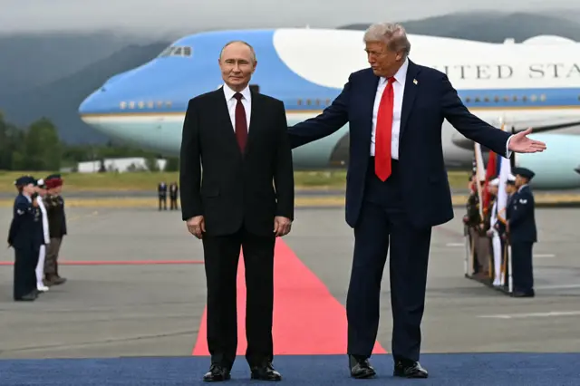 US President Donald Trump (R) and Russian President Vladimir Putin pose on a podium on the tarmac after they arrived at Joint Base Elmendorf-Richardson in Anchorage