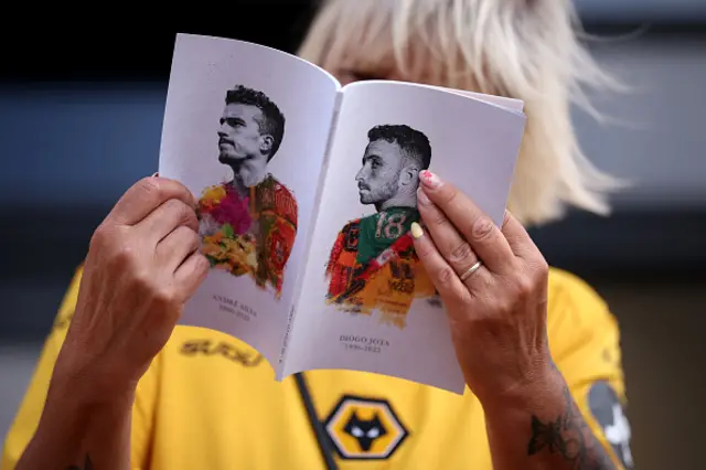 A Wolverhampton Wanderers fan reads the match programme with Diogo Jota and Andre Silva