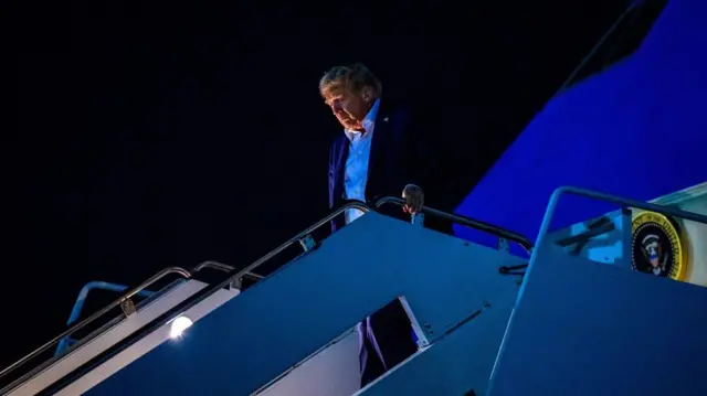 Trump walks down the steps of Air Force One