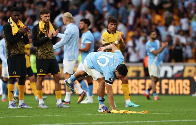 Cherki touches the shirt bearing Diogo Jota's name on the turf at full time
