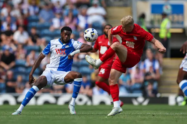 Birmingham City's Alex Cochrane passes the ball despite the attentions of Blackburn Rovers' Ryan Alebiosu