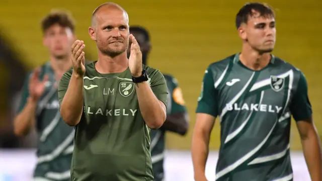 Norwich head coach Liam Manning applauds the Canaries fans after his side's 2-1 win at Watford