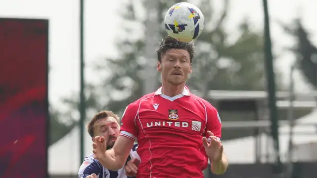 Kieffer Moore heading the ball for Wrexham