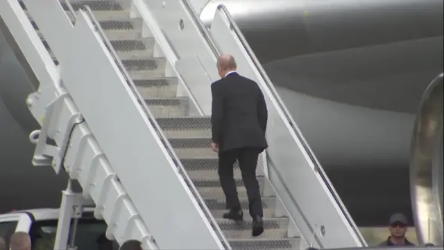 Putin walks up the stairs to his plane