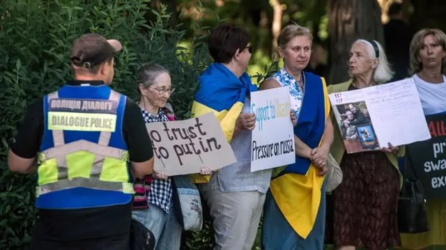 A row of women holding signs in support of Ukraine