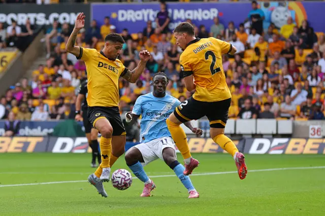 Jeremy Doku of Manchester City battles for possession with Matt Doherty and Joao Gomes