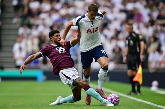 Burnley's English midfielder #29 Josh Laurent (L) challenges Tottenham Hotspur's Dutch defender #37 Micky van de Ven