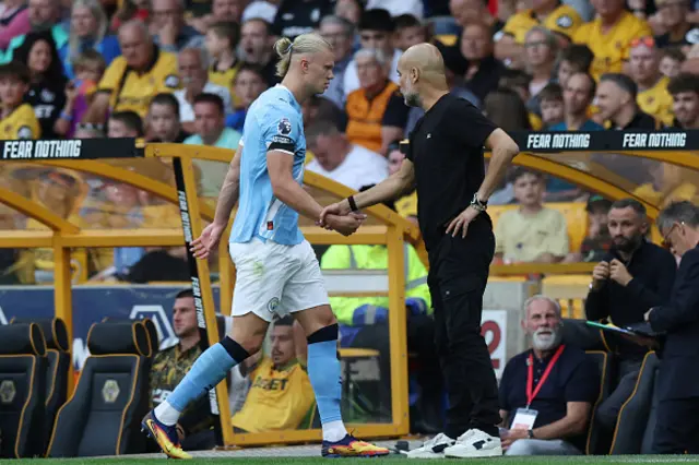 Manchester City's Spanish manager Pep Guardiola (R) reacts with Manchester City's Norwegian striker Erling Haaland