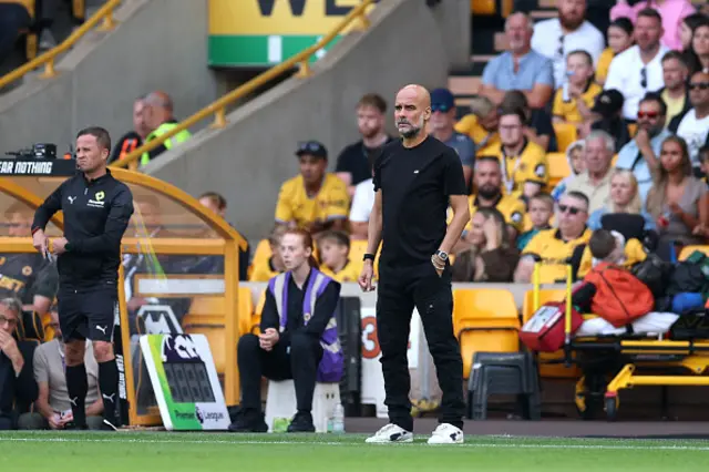 Pep Guardiola, Manager of Manchester City looks on