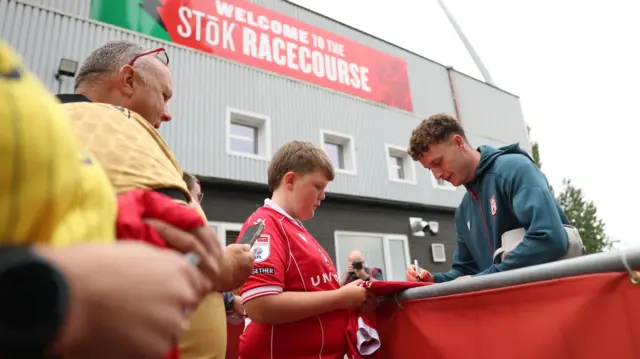 Wrexham's new signing Nathan Broadhead signing autographs as he arrives at the Racecourse Ground