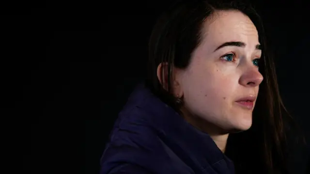 A woman looks off frame.