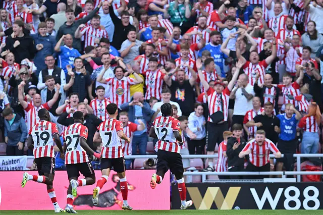 Sunderland fans celebrate a goal as the players run to join them