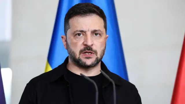 Zelensky speaks into a microphone