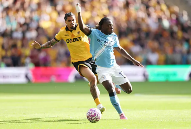 Jeremy Doku of Manchester City is challenged by Ki-Jana Hoever