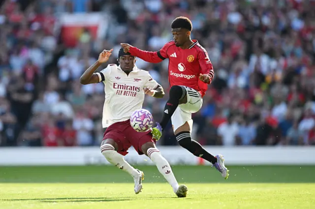 Amad Diallo of Manchester United is challenged by Noni Madueke
